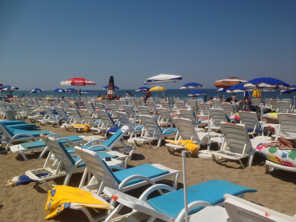 Deniz Feneri Beach kumsalında sıra sıra dizilmiş şezlong ve şemsiyeler, arkada Marmara Denizi